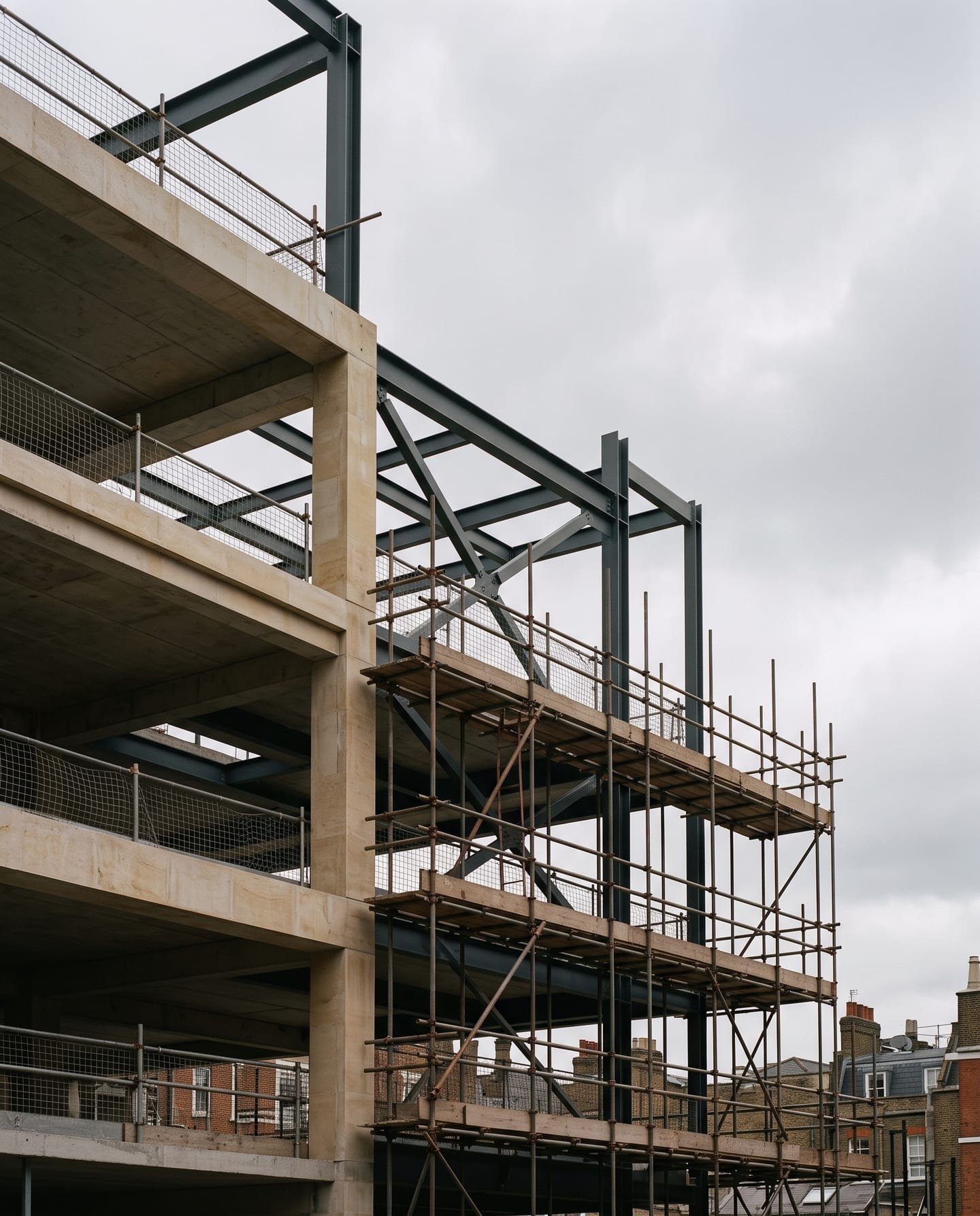 Concrete frame and steelwork of a building under construction, with scaffolding